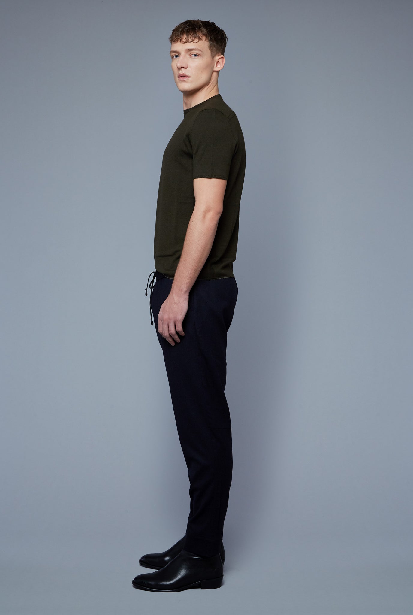 Side View: Model Milos Drago wearing Short Sleeve Sweater Tee
