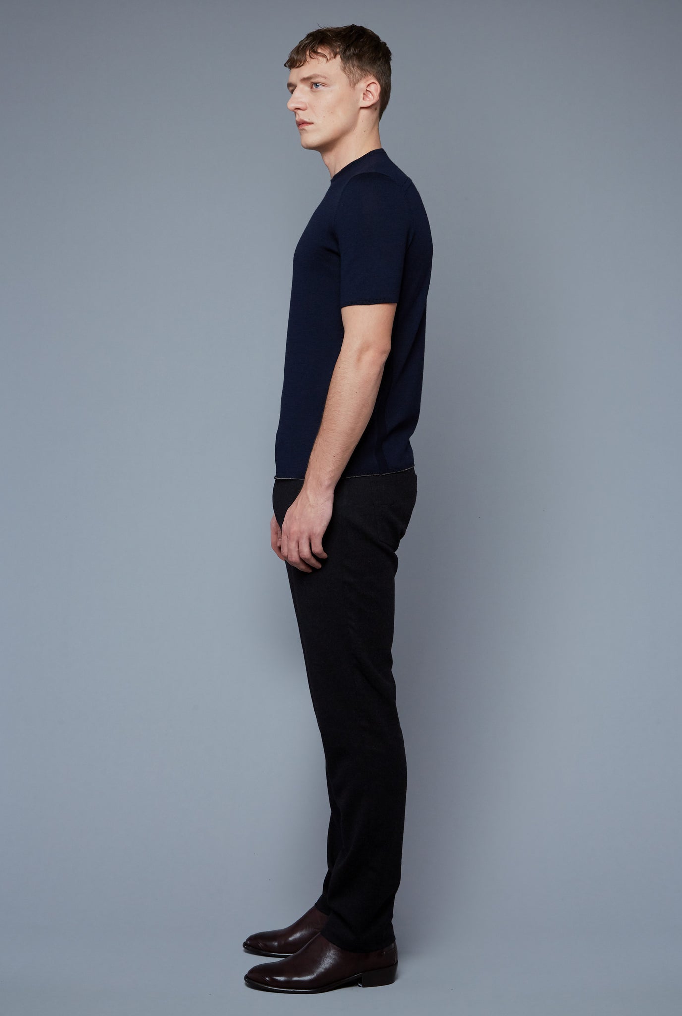 Side View: Model Milos Drago wearing Short Sleeve Sweater Tee