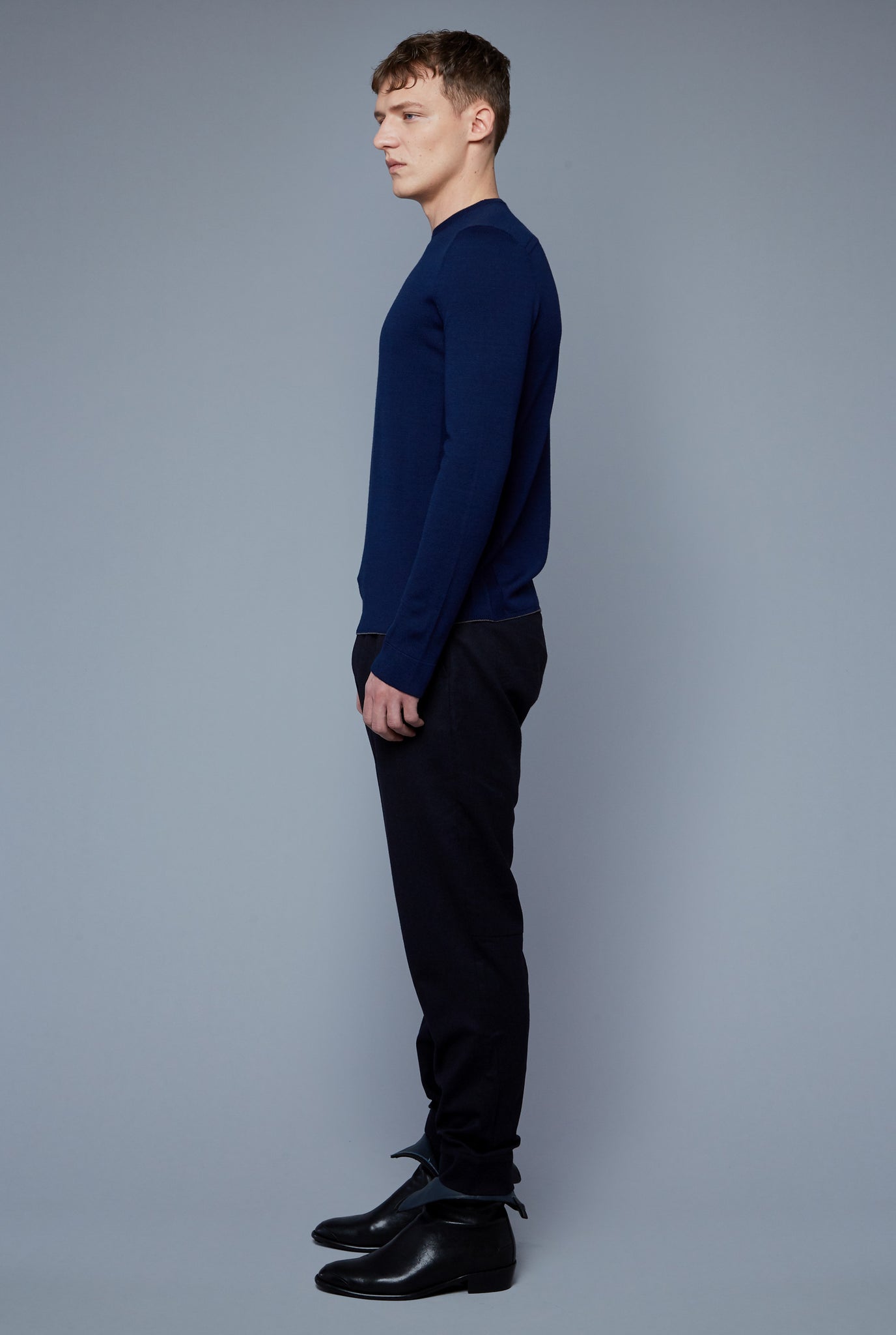 Side View: Model Milos Drago wearing Long Sleeve Sweater Tee